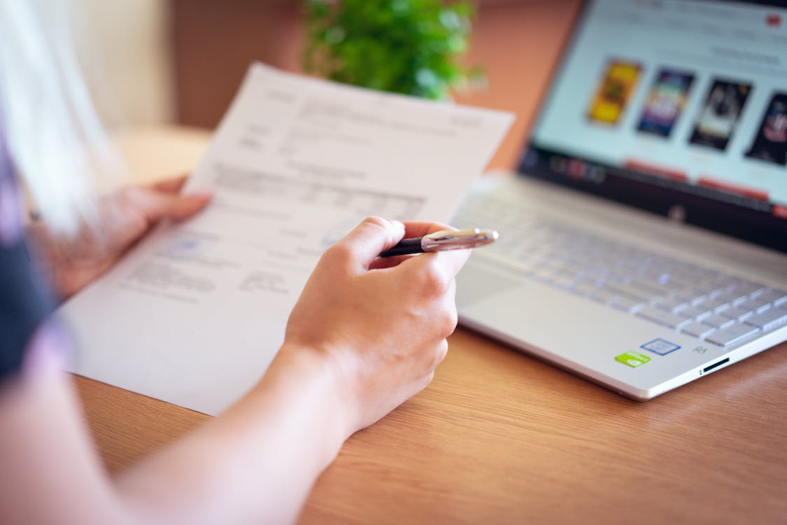 a person holding a pen and paper