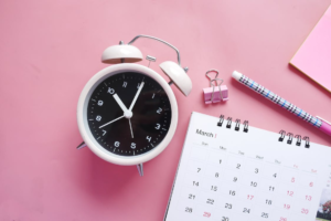 calendar and clock on a pink surface