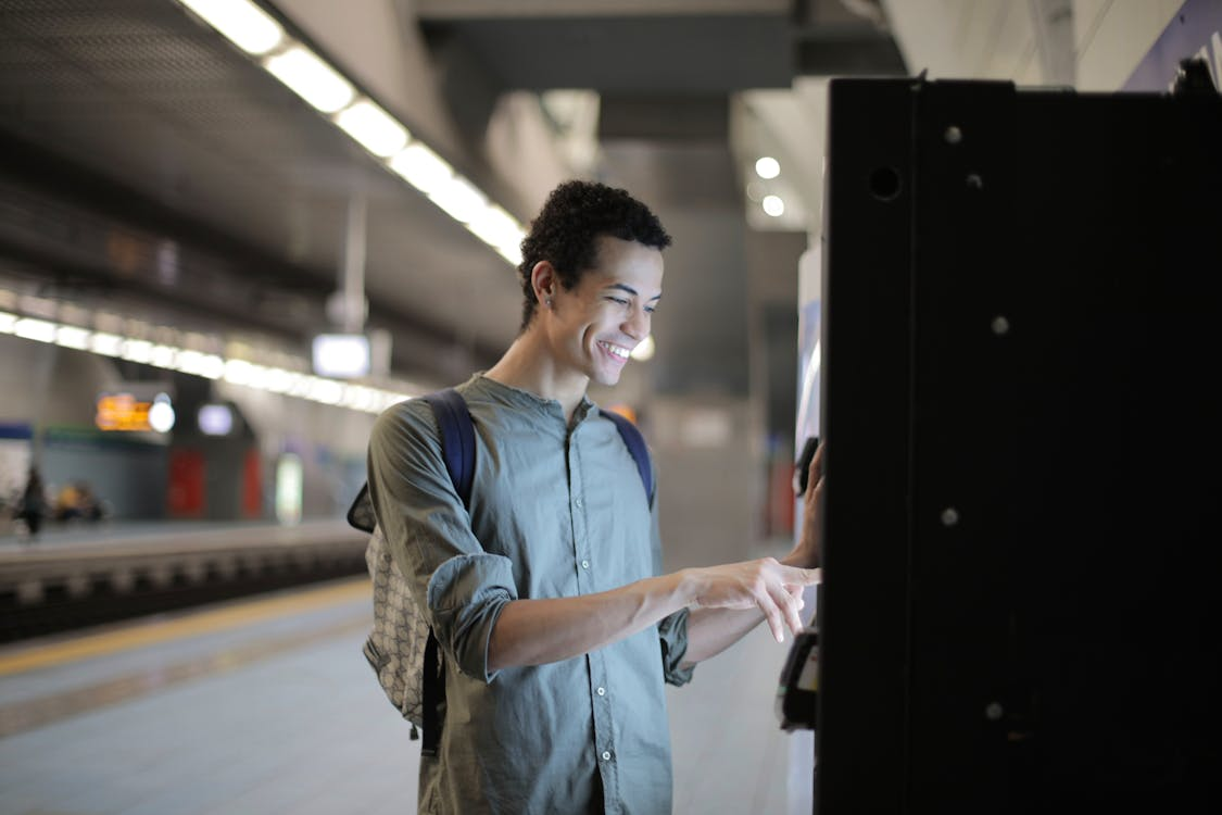 A person is smiling and using an ATM machine