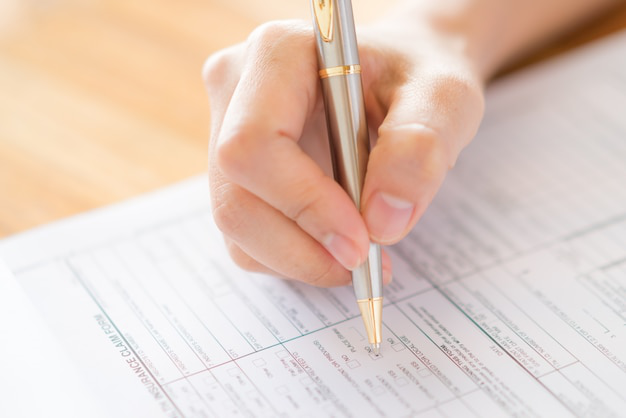 person filling the form with a pen