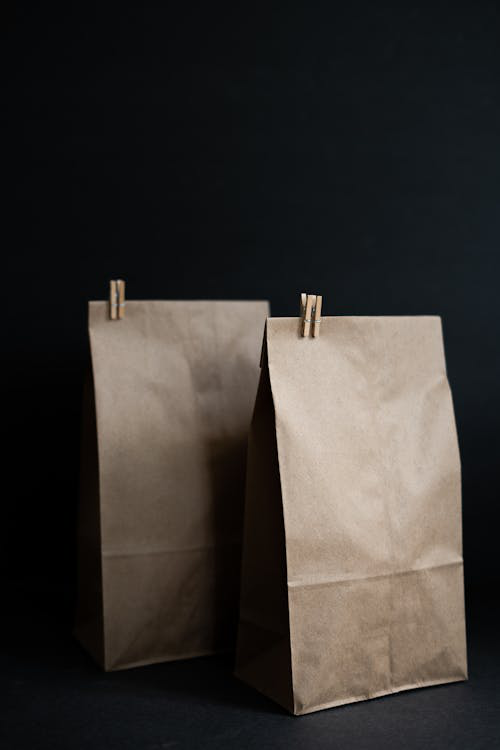 Two brown paper bags with wooden clips