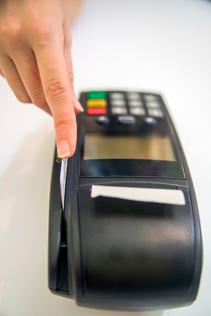 A person swipinh her credit card using the credit card machine with a receipt coming out