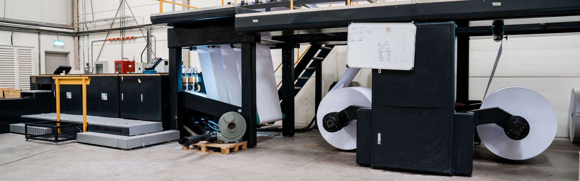 An image of a large paper-making machine in a factory.
