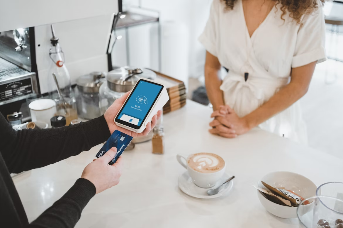 Woman holding smartphones while making a digital transaction, representing POS system use.