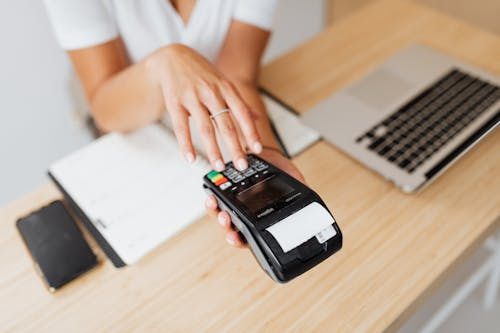 Person interacting with a payment terminal, representing secure financial transactions.